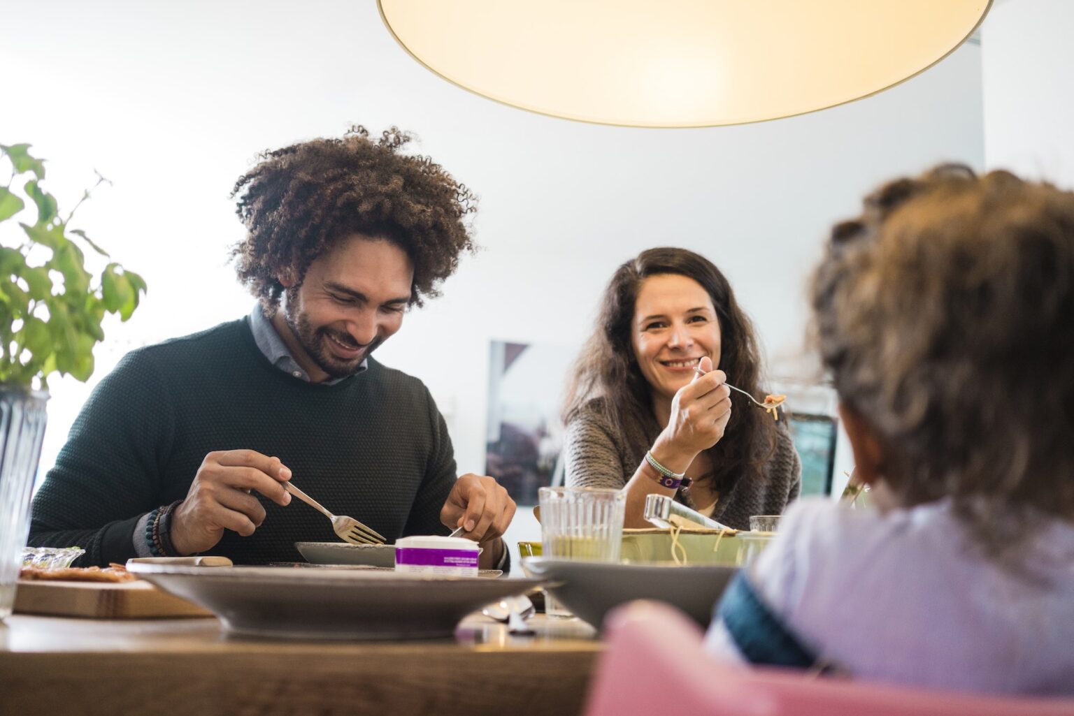 Happy family eating together pizza and pasta